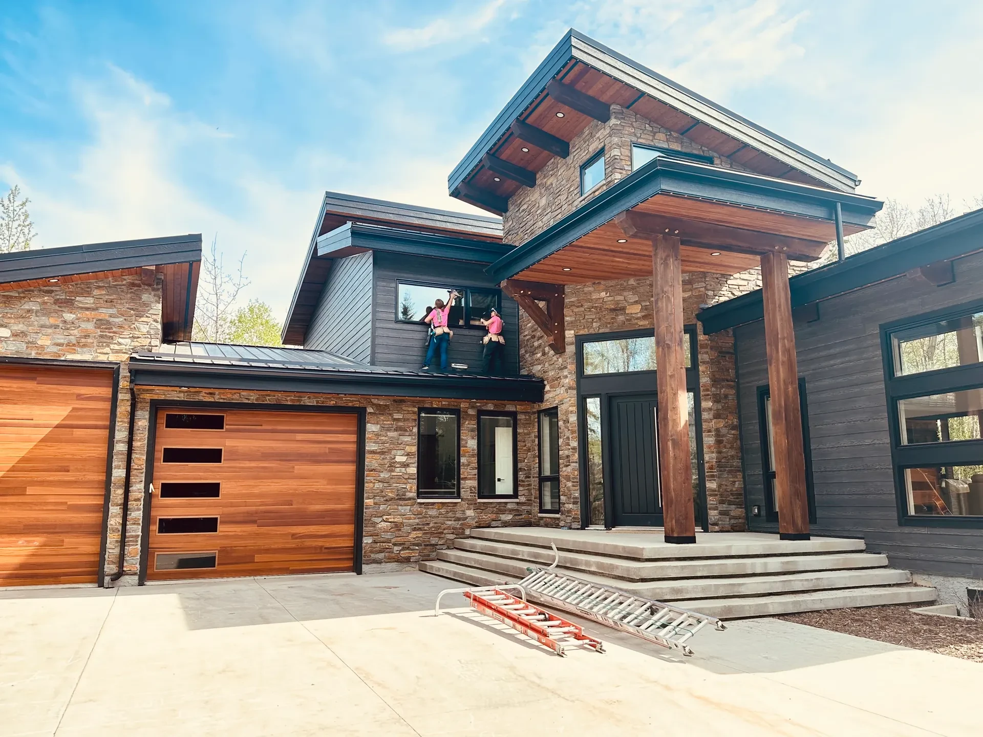 Peace Home Services team cleaning windows on a modern mountain home near Grande Prairie